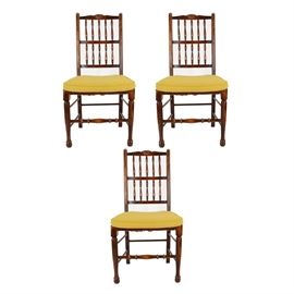 Set of Federal Style Dining Chairs: A set of Federal style dining chairs. These three chairs feature a straight crest rail with a shell motif to the center over a turned spindle back flanked by straight stiles over a square rush seat with upholstered yellow toned cushion. The chairs rise on turned legs terminating in ball feet supported by a box stretcher with a turned spindle to the front.