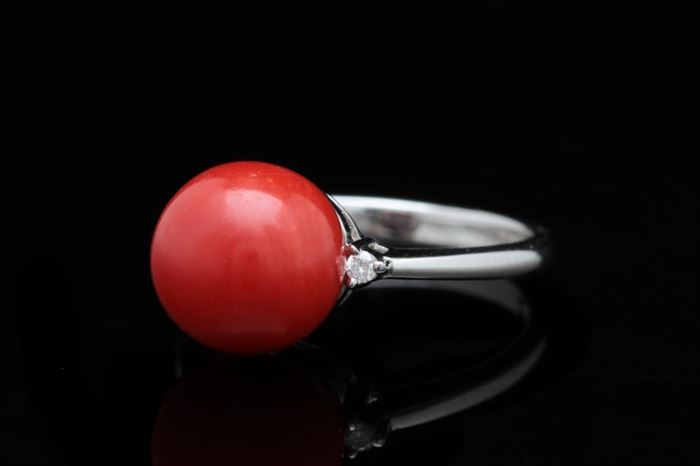 14K Gold, Red Chalcedony and Diamond Ring: A 14K gold, red chalcedony and diamond ring featuring a round red chalcedony cabochon accented with two round brilliant diamonds at the shoulders.