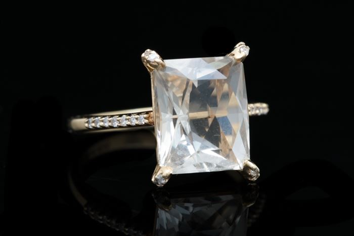 14K Gold, White Quartz, and Diamond Ring: A 14K gold, white quartz and diamond ring. 
The ring features a rectangular white quartz set with four prongs accented with diamonds. The shoulders are also embellished with eighteen round single cut diamonds.