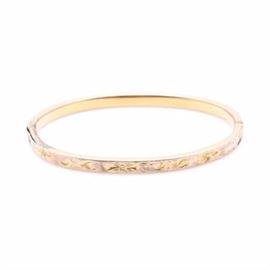 10K Yellow Gold Baby Bangle Bracelet: A 10K yellow gold bangle bracelet. This baby bracelet is a hinged bangle that features decorative engraved design.