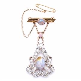 10K - 14K Yellow Gold and Platinum Opal and 1.56 CTW Diamond Pin: A 10K – 14K yellow gold and platinum opal and 1.56 ctw diamond pin. This pin features an Art Deco inspired design. There is a 10K yellow gold openwork bar pin with a chain attaching a dangling platinum and 14K yellow gold pin. A safety pin on a chain is affixed to the side.