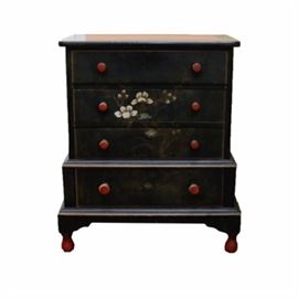 Stickley Brothers Co. Painted Chest of Drawers: A Stickley Brothers Co. painted chest of drawers. This chest of drawers is made of wood and has a hand painted design across the front of the drawers. There are four drawers down the front of this piece. It has a tiered design with the lower sections being slightly larger than the upper section. The top surface also has a painted floral design in the front corners. The wooden drawer pulls and legs are painted bright red. The interior of the drawers are painted gray. This piece is marked Stickley Brothers Co. Quant American Furniture to the inside of the top drawer.