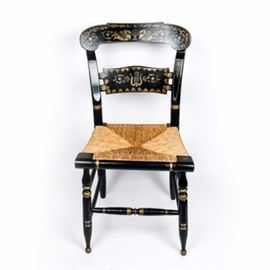 Authentic Vintage Hitchcock Painted Chair by Ethan Allen: An authentic vintage Hitchcock painted chair. This vintage 1980s chair has a wooden frame and woven, straw seat. The frame is painted black with an ornate gold-toned floral and swan motif painted across the seat back, legs, and edging. Along the back of the seat, the chair is marked Ethan Allen Button Back Hitchcock in stenciling.