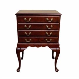 Mahogany Silverware Chest: A mahogany silver chest. This chest is made of mahogany stained with a cherry toned, polished wood. It has four drawers down the front including three that are divided in the center. Each drawer features a pair of gold toned metal pulls and dovetail joints. This chest is set on high legs that have a curved design and claw feet. The chest is unmarked.