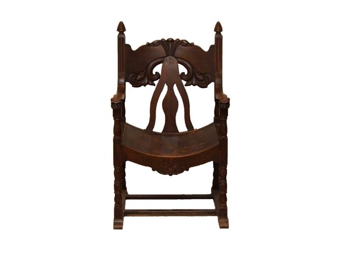 Antique Carved Wooden Throne Chair: An antique carved walnut wood throne chair. This dark walnut chair features a carved floral head rest, a cutout back rest with curved seat, two gently curved arms with lions heads to the hand rest, turned legs connected by side and center stretcher.