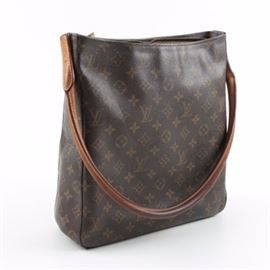 2001 Louis Vuitton Monogrammed Canvas Looping Handle Tote: A Louis Vuitton Monogram Looping Tote. This classic bag features a zippered top with a single rolled leather handle and branded brass hardware. The bag is finished with a tan chemise lining, an interior zippered pocket, a key fob and branded markings. The serial number for this purse is “MI0051”.