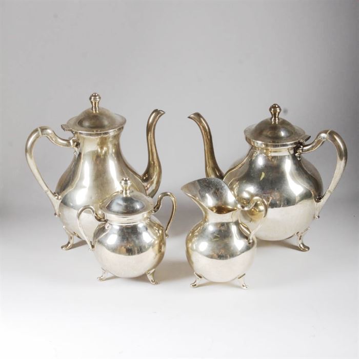 Sterling Silver Tea and Coffee Set from Mexico: A sterling silver coffee and tea service from Mexico. The service includes a lidded coffee pot, a lidded teapot, a lidded sugar bowl with two handles and a creamer pitcher. The pieces in the set are all marked “Sterling 925 Hecho En Mexico”, along with a hallmark with the number “37” inside a mark, and a triangular mark. Total approximate weight, 98.010 ozt including precious and non-precious materials.