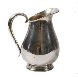 International Silver Co. Sterling Silver "Royal Danish" Pitcher: A sterling silver pitcher by International Silver Co. in the Royal Danish pattern. The pitcher has a slanted top with spout, a graceful handle and a wide bottom and round base. The pitcher is unadorned except for some raised bands encircling the handle at the top and at the bottom. The underside is marked “Royal Danish U.S.A. International Sterling 4 PTS 130 17”. Total approximate weight, 20.910 ozt.