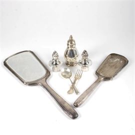 Vintage Sterling Silver Decorative Items and More: A collection of vintage sterling silver items. This collection features a total of seven items. Featured items include one hand mirror marked “SB STERLING” with a hallmark in between the letters, one hand mirror with the mirror removed, marked “S B STERLING” with the same hallmark in between the letters; one spoon marked “STERLING” with a hallmark and one fork marked “Reed & Barton, STERLING”. Also included are two antique candleholder covers with Birmingham hallmarks, including a lion, anchor, the maker’s mark for Matthew Boulton, the date mark for 1793, the George III duty mark. They are engraved, “A PIN” with the initials “WO” engraved in script. This is presented together with one salt shaker stamped “ROYAL DANISH U.S.A. INTERNATIONAL STERLING 130 64 /2.” The total approximate weight is 11.55 ozt excluding the weighted hand mirror.