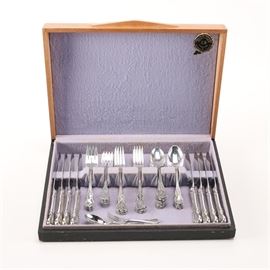 Towle "Old Master" Sterling Silver Flatware: A sterling silver flatware set by Towle Silversmiths. In the Old Master pattern, these feature foliate embellished fiddle handles. This includes eight dinner knives with stainless steel blades, eight dinner forks, eight salad forks, and sixteen teaspoons. The lot also includes a teaspoon in a Rococo style pattern and a diminutive baby fork in a complementary pattern. The set in presented in a wooden case. The total approximate weight, excluding the knives with stainless blades, is 39.655 ozt.