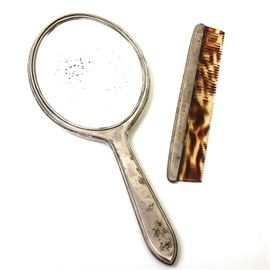 Vintage Sterling Silver and Tortoise Shell Comb & Mirror by Gorham: A vintage sterling silver backed hand-mirror and a sterling silver and tortoise shell comb. The mirror glass is oval and has beveled edges. It is housed in a sterling silver frame with a handle and the back of the mirror has vertical raised stripes and an engraved monogram, “JSA”. The comb features a sterling silver spine, which is monogrammed inside an oval in the center.