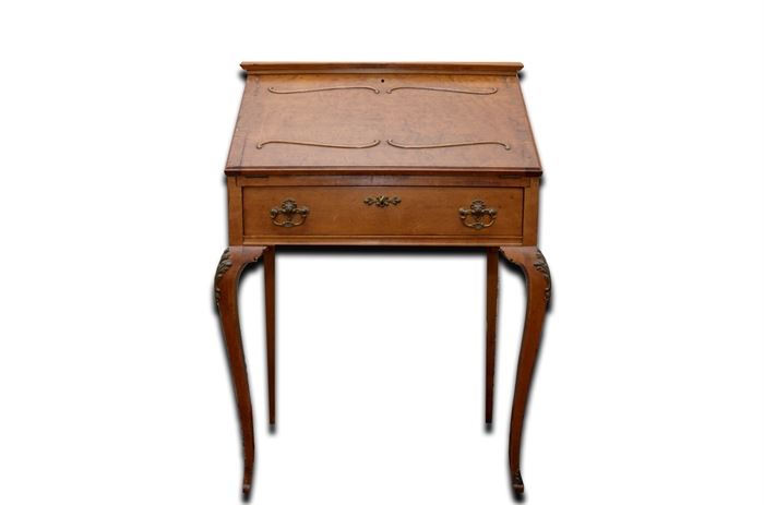 Louis XV Style Secretary: A Louis XV style secretary. This secretary features a slant front that opens to a writing surface with a pair of small drawers and storage slots above a drawer with lion head pulls. The piece rises on cabriole legs with acanthus mounts to the knees and feet.