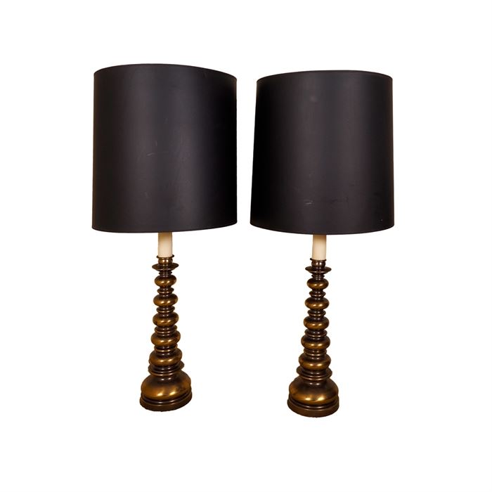 Pair of Brass Tone Lamps: A pair of brass tone lamps. The lamp bases of stacked metal balls in graduating sizes are topped with black shades.