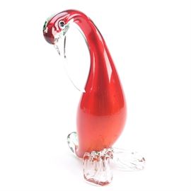 Glass Bird Figurine: A glass bird figurine. This blown art glass figurine depicts a red, yellow and green bird with curved neck, black eyes, rounded body with curved tail feathers and clear beak and feet.