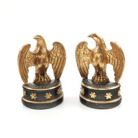 Borghese American Eagle Bookends: A pair of American eagle bookends by Borghese. Each depicts a gold tone eagle with wings slightly open, standing on a black demilune base ornamented with gold toned stars.The bookends have flat backs with small attached stands and are marked on the undersides.