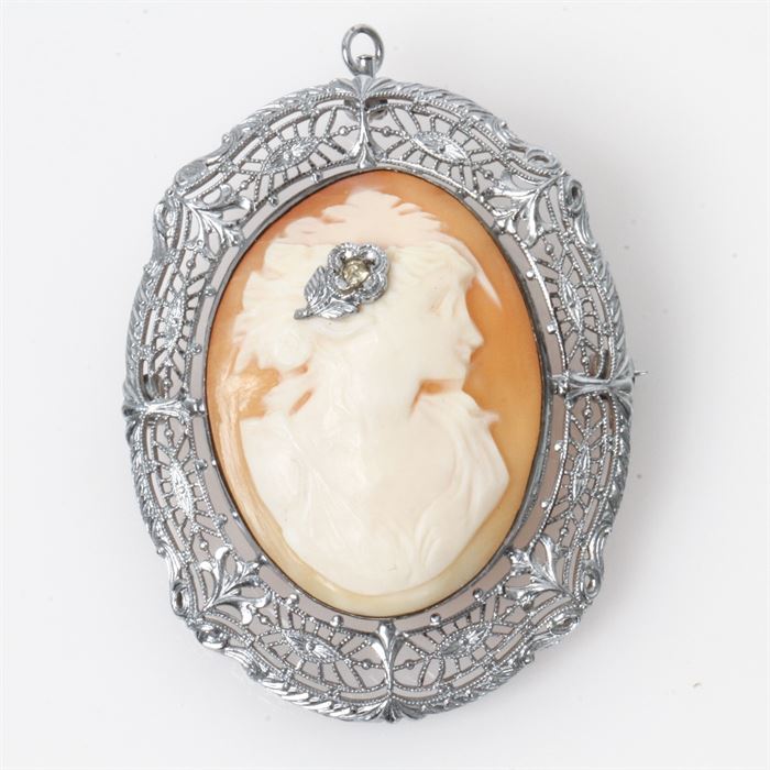 Vintage Art Deco Ostby & Barton Sterling Silver and Carved Shell en Habillé Cameo Pendant Brooch: A vintage Art Deco sterling silver and carved shell en habillé cameo pendant brooch. The piece depicts the portrait of a woman with a diamond and milgrain flower in her hair and a filigree frame with milgrain details and etched designs.
