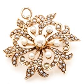 14K Yellow Gold Cultured Pearl Brooch: A 14K yellow gold cultured pearl brooch features gemstones set in an openwork floral pattern. Small pearls circle a larger center pearl while the outside leaves hold cultured seed pearls. A fold over bail allows the piece to be worn as a brooch or pendant.