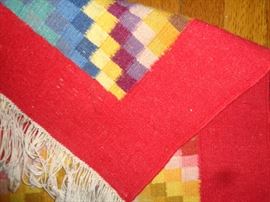 CLOSE UP VIEW OF HAND WOVEN NEEDLE POINT GEOMETRICAL RUG WITH OVER 800 WEAVES PER SQUARE INCH