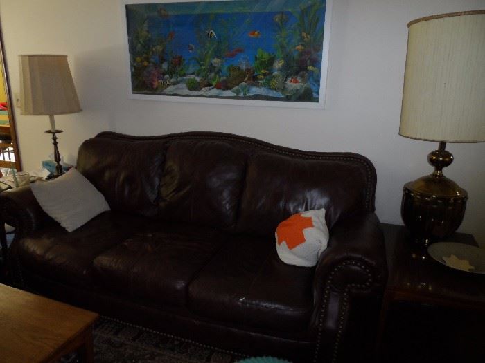 Brown leather sofa and loveseat.  Large base lamp