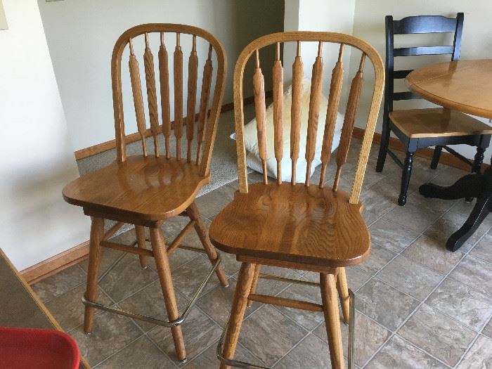 Two matching oak bar stools.