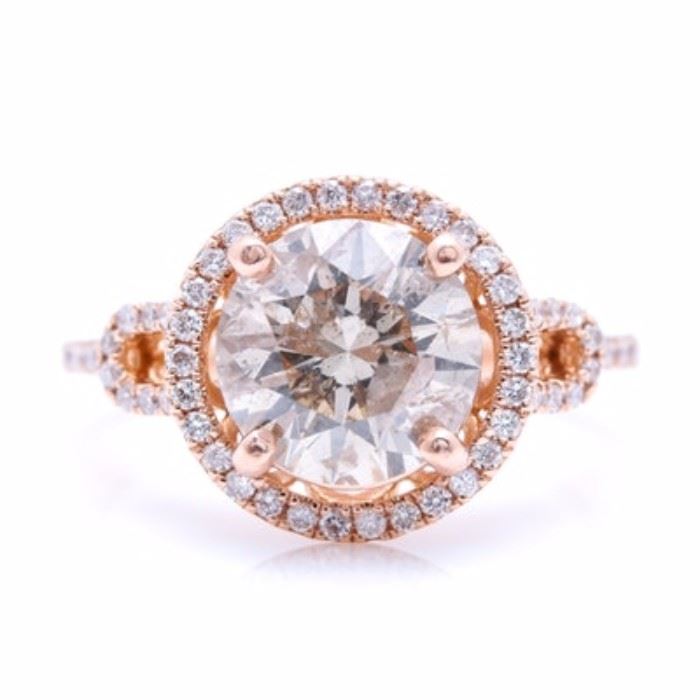 14K Rose Gold 2.97 CTW Diamond Ring: A 14K rose gold 2.97 ctw diamond ring. This ring features a center prong set diamond encircled by a halo of prong set diamonds above a pierced gallery flanked by split diamond set shoulders.