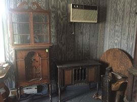 Old radio, record holder (front tilts open) and wall glass door cabinet.