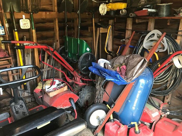 Back shed filled with massive amount of lawn equipment including a large Troy-built rototiller