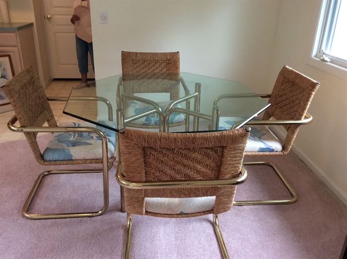 Brass and glass dinette table with four wicker chairs