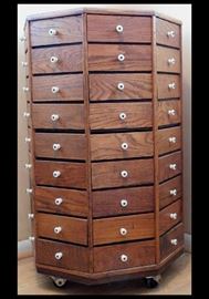 Oak bolt cabinet with enameled knobs. Has 72 drawers