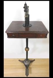 Foot operated cobbler's tool. More than 4 feet tall. Walnut cabinet with two drawers.