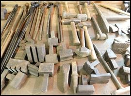 Blacksmith tools including tongs, hardies, stakes, flatters, hammers, and more.