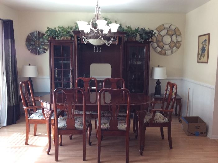 Formal Cherry mahogany dining table with 6 chairs and two leaves. In background Cherry entertainment center.