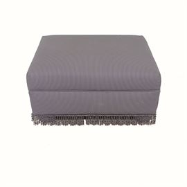 Purple Striped Ottoman: A rectangular ottoman. This cushioned ottoman is upholstered in purple and white striped upholstery with a beaded fringe. It is supported by upholstered bun feet.