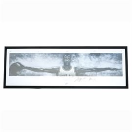 Michael Jordan Signed Limited Edition Lithograph "Wings": A Michael Jordan signed limited edition lithograph titled Wings by Nike and Upper Deck. The print depicts Michael Jordan’s spanning his arms and palming a basketball in his right hand. The print is titled above the image of Jordan, and below the print reads “No bird soars too high, If he soars with his own wings. – William Blake”. It is additionally marked with Jordan’s autograph in black permanent marker, edition number 16/100, and hologram BAM05311. The wide print is presented under plexiglass in a beveled black wooden frame. The back is covered in black paper and has fixed hardware but is missing its hanging wire. The verso features an affixed envelope with Certificate of Authenticity from Upper Deck and hologram.