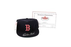 Carlton Fisk Autographed Official Red Sox Cap with COA by Fleer: A Carlton Fisk autographed official Red Sox cap with Certificate of Authenticity by Fleer Genuine Memorabilia. The black baseball cap is signed in silver permanent marker to the bill, features the Red Sox’s red “B” logo, and retains its original tag from the New Era Cap Co. The COA from Fleer states the hat is an autographed official limited edition Red Sox cap. A sticker from Fleer numbers the item 1673210 to the inside of the bill.