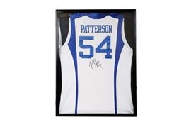 Framed University of Kentucky Patrick Patterson #54 Signed Jersey: A signed and framed Patrick Patterson University of Kentucky jersey. This blue and white UK jersey is signed “P. Patt #54” in black permanent marker to jersey’s back beneath the number. Patrick Patterson played collegiately for the University of Kentucky from 2007-2010, and currently plays in the NBA for the Oklahoma City Thunder. The jersey is presented mounted behind glass in a hinged black wooden display case that is wired to hang.