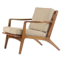 Danish Modern Lounge Chair: A mid-century, Danish Modern lounge chair. This chair features a dark-stained, teak construction with shaped arms, spindle back, and splayed back legs. The seat and back cushions are covered with a gray tweed fabric upholstery. Marked on the seat rail under the cushion, “Made in Denmark”.