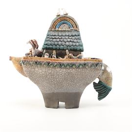 Raku Zoo Noah's Ark Figurine: A Raku Zoo Noah’s ark figurine. This figurine depicts Noah’s ark with a variety of animals on deck. The figurine comes is marked “Chris Moses ceramic sculpture” to the label.
