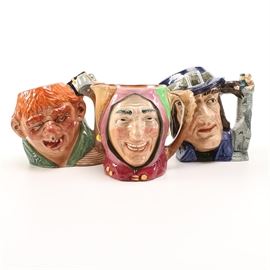 Royal Doulton Ceramic "Quasimodo," "Gulliver" and Jester Mugs: A collection of collectible detailed character mugs manufactured by Royal Doulton. This collection features three mugs; including one jester mug with a colorful headdress and exposed face; and one limited edition Hunchback of Notre Dame “Quasimodo” mug, marked “Royal Doulton, Quasimodo, D7108, Modelled by David B. Biggs, ©1998 Royal Doulton, Limited Edition of 2,500, This is No. 469.” Also included is one “Gulliver” mug, inspired by Gulliver’s Travels, marked “Made in England, Royal Doulton, Gulliver, D6560, Copr. 1961.”