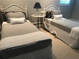 Simple set of sturdy white twin beds and linens

