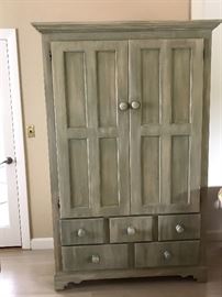 Storage armoire featuring shelves and drawers