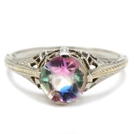 Vintage 18K White Gold Ring with Glass Center Stone: A vintage 18K white gold ring featuring a round faceted glass stone on an openwork setting with milgrain detail.