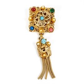 Kramer of New York Vintage Costume Brooch: A gold-tone vintage costume brooch. The brooch features a square filigree square set with round colored glass and faux pearl stones, with a gold-tone braided tassel at the bottom. It is marked “Kramer of New York”.