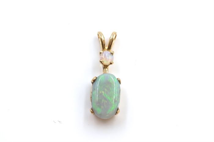 14K Yellow Gold Opal Pendant: A blue green oval opal is prong set to a yellow gold split bale pendant with small round white opal accent to the top.