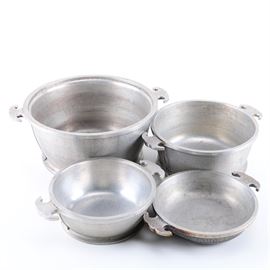 Collection of Guardian Service Metal Cookware: A collection of Guardian Service metal cookware. The group of four two-handled dishes includes a large pot, two medium pots, and a small shallow dish. Each is marked “Guardian Service” on the underside.