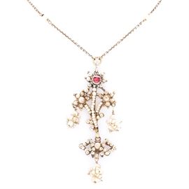 Victorian 14K Yellow Gold Pearl and Ruby Pendant With Gold Filled Chain: A Victorian 14K yellow gold pearl and ruby pendant with gold filled chain. This necklace features a floral motif pendant set with pearls and a ruby that is affixed to a gold filled chain accented with pearls.