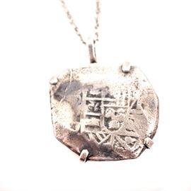 Antique Spanish Colonial "Shield Type" 8 Reales Cob on Sterling Silver Chain: An antique Spanish Colonial “Shield Type” 8 Reales Cob on a sterling silver chain. The Spanish struck this coin in America between 1572 and 1607. Open mounted with five arms bent to the edges, this coin is on a sterling silver link chain. The total approximate weight, inclusive of all materials is 1.090 ozt.