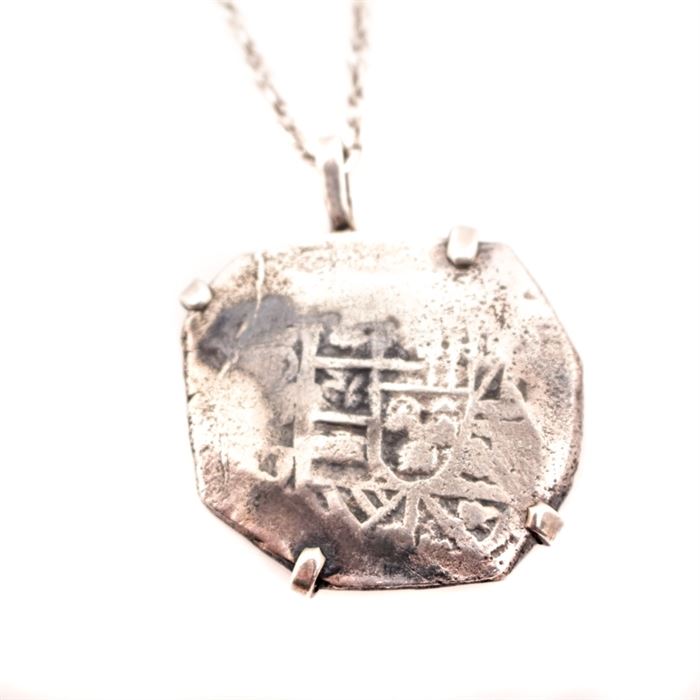 Antique Spanish Colonial "Shield Type" 8 Reales Cob on Sterling Silver Chain: An antique Spanish Colonial “Shield Type” 8 Reales Cob on a sterling silver chain. The Spanish struck this coin in America between 1572 and 1607. Open mounted with five arms bent to the edges, this coin is on a sterling silver link chain. The total approximate weight, inclusive of all materials is 1.090 ozt.