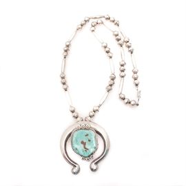 Vintage Sterling Silver and Turquoise Squash Blossom Necklace: A vintage sterling silver squash blossom necklace with natural turquoise. Maker’s mark to reverse. Total approximate weight, inclusive of all materials is 2.640 ozt.