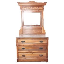 Antique Marble Topped Eastlake Style Dresser with Mirror: An antique, solid wood dresser in the Eastlake style. This dresser features an attached carved wood encased mirror upon a pink marble topped three drawer dresser with metal pulls.